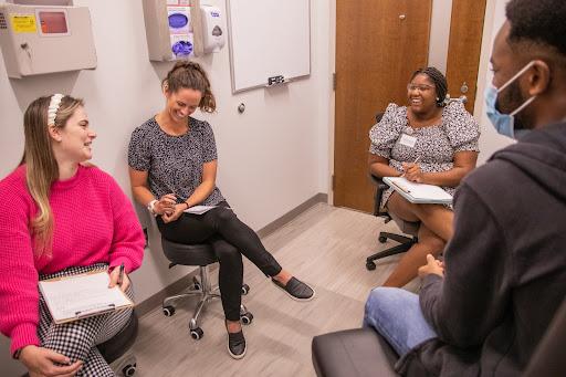 Group of people in medical office talking and taking notes.